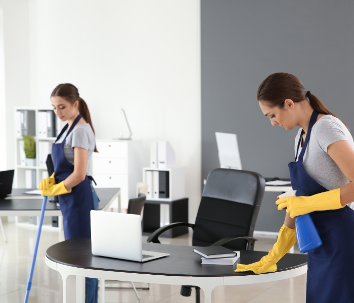Technician wiping down classroom desks and vacuuming hallways—providing scheduled cleaning for educational facilities across Auckland.